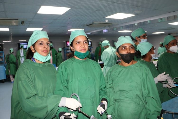 Gynecologists are conducting an interactive laparoscopic wet lab where they practice various surgeries on live tissue, including laparoscopic tubal sterilization, salpingostomy, ovarian drilling, hysterectomy, pelvic lymphadenectomy, and ovarian cyst